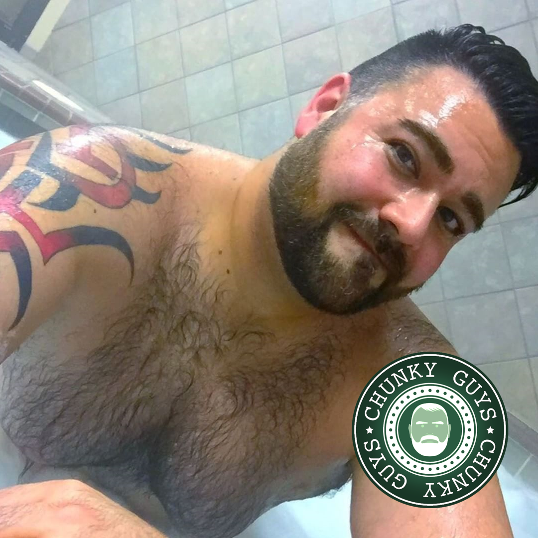 Bearded tattooed bear sitting in a bath