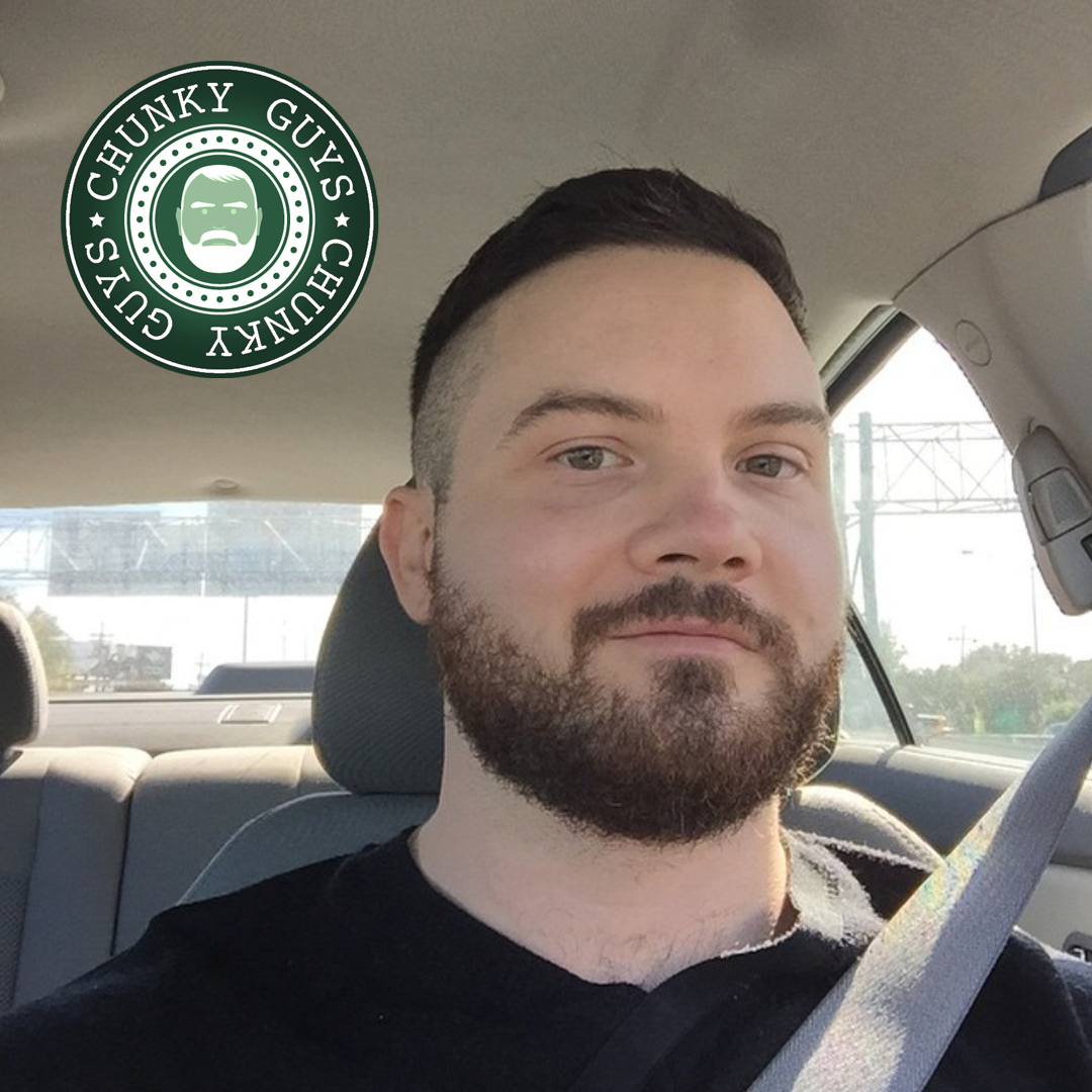 Young bearded buy with dark hair sitting in a car