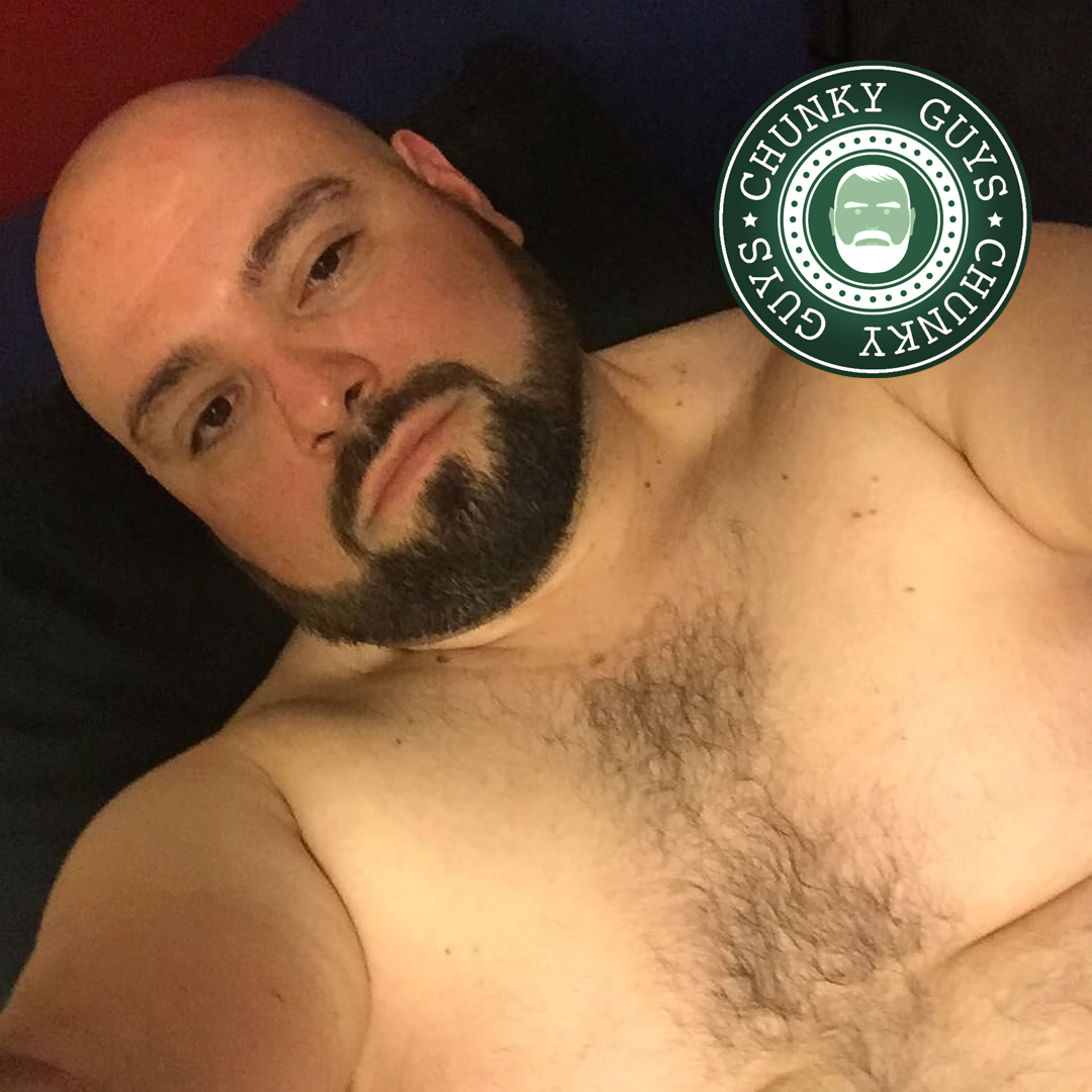 Bearded beary guy with shaved head and a hairy chest