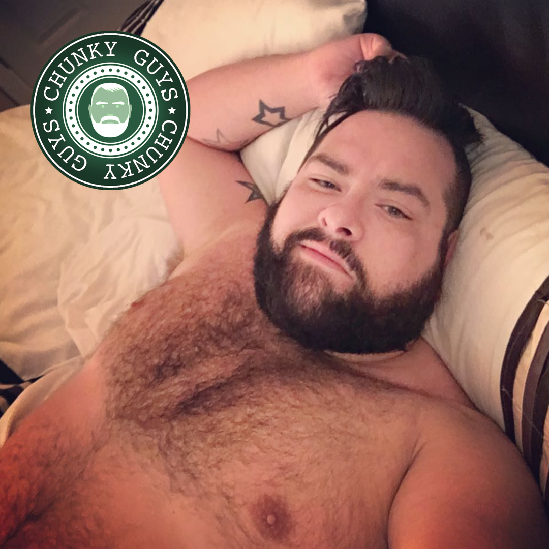 Bearded hairy beary guy with dark hair lying in bed