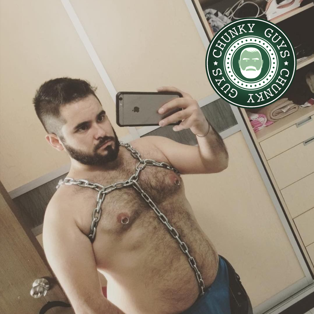 Hairy bearded cubby guy with dark hair wearing a chain harness