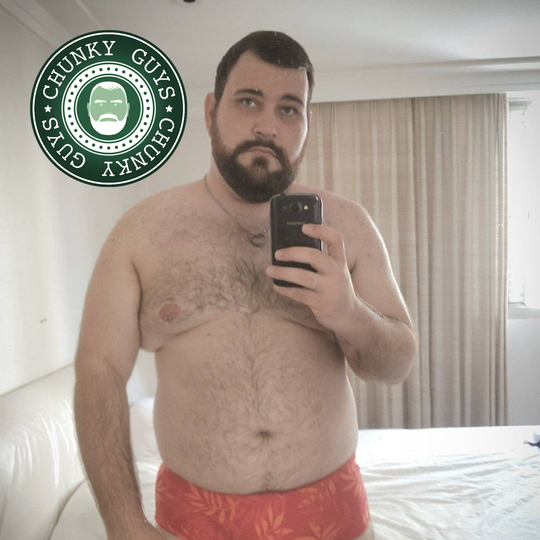 Beary guy with a beard stands in his red underwear and takes a photo of himself in the mirror
